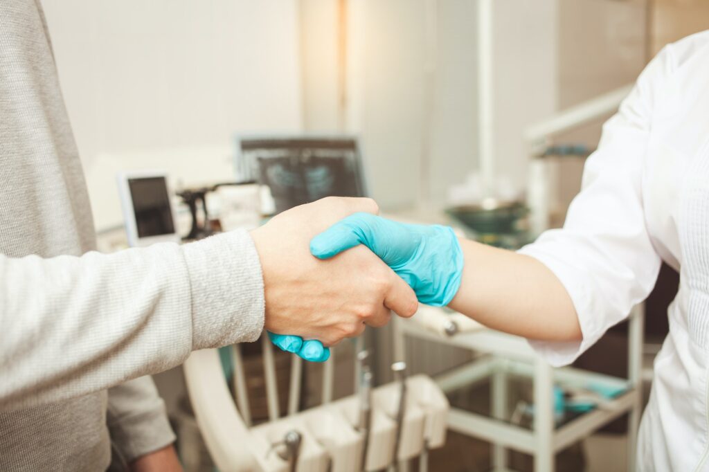 Doctor and patient shaking hands in Creve Coeur Family & Sedation Dentistry clinic, Creve Coeur, MO, embodying patient satisfaction and friendly, professional dental care in the local community.