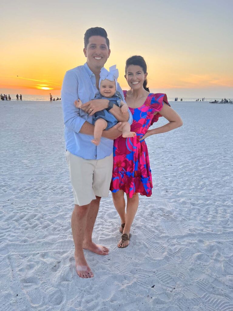 Dr. Kratz enjoying a sunset beach moment with his wife and baby, showcasing the personal side of our Creve Coeur dental team.