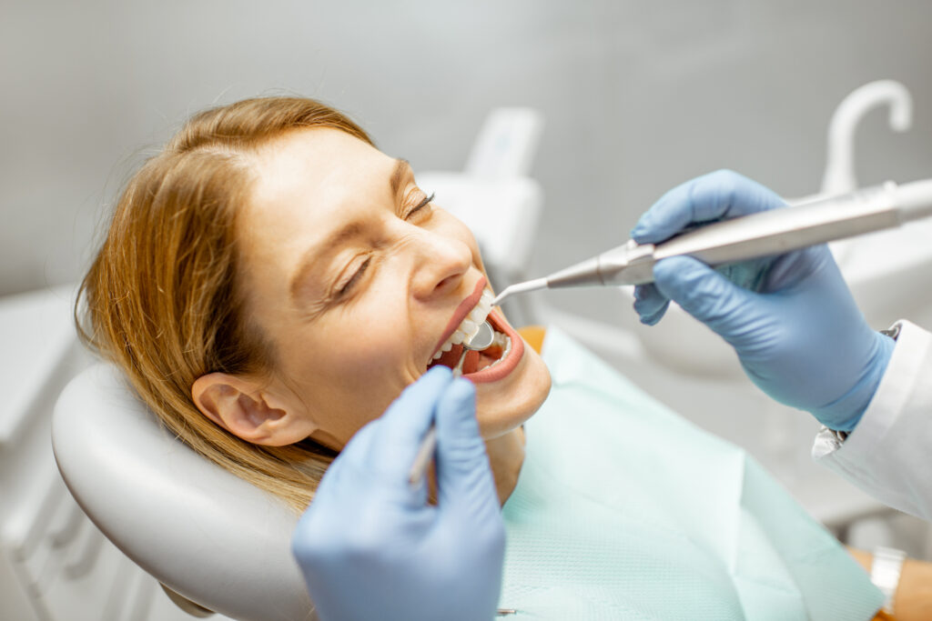 Woman receiving a dental inspection in a Creve Coeur dental office, exemplifying professional dental examinations.