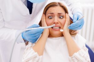 Nervous woman in dental chair during exam, illustrating dental anxiety before sedation dentistry at Creve Coeur Family & Sedation Dentistry in MO.